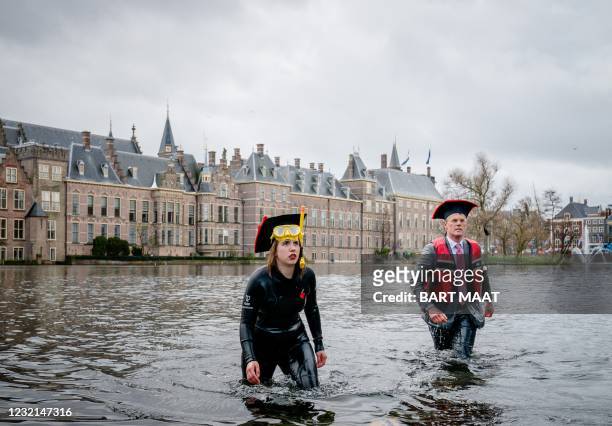 Activists leave after bathing in the Hofvijver lake in the Hague, on April 6, 2021 during a demonstration to indicate that science is all about...
