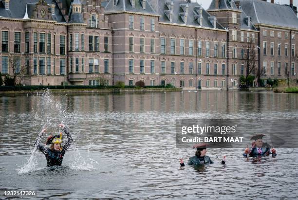 Protesters swim in the Hofvijver lake in the Hague, on April 6, 2021 during a demonstration to indicate that science is all about water. -...