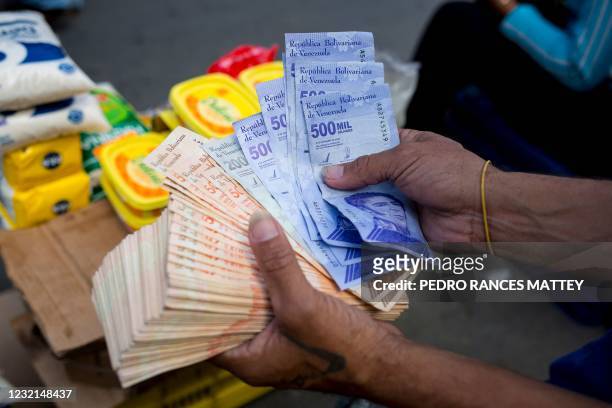 Man holds Bolivar bills a street market in Caracas' Catia neighborhood, on April 6 amid the Covid-19 pandemic.