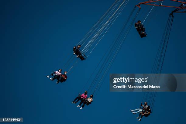 People wearing face masks to stop the spread of coronavirus enjoying the 'flying chairs' in the Amusement Park of Madrid. The park has adapted and...