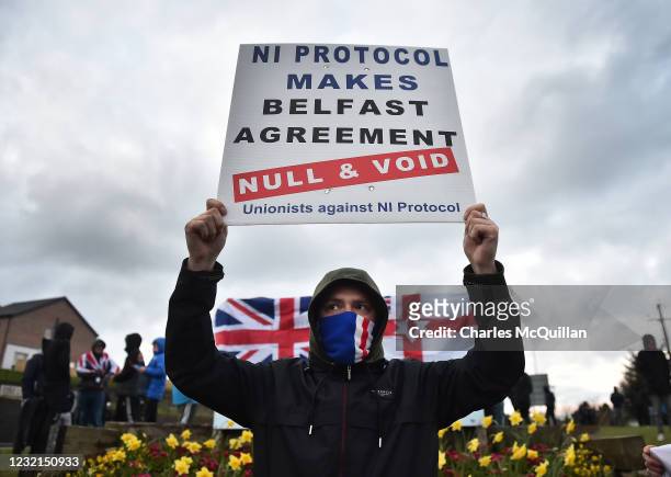 Loyalists hold up placards during an anti Northern Ireland Protocol protest against the so called Irish Sea border on April 6, 2021 in Larne,...