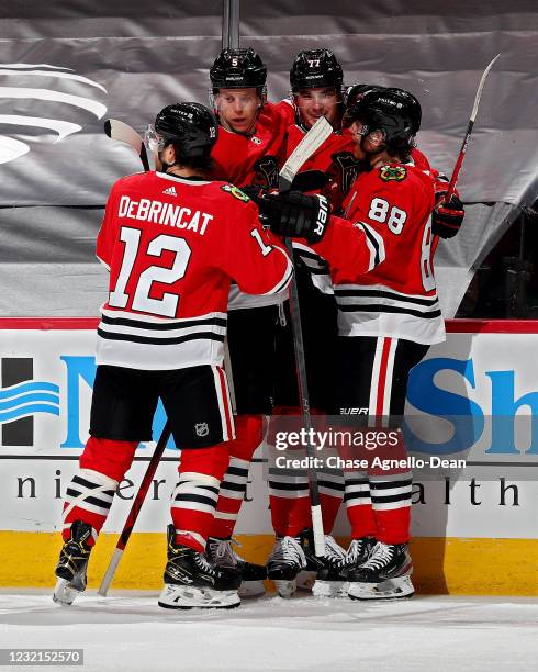 Kirby Dach of the Chicago Blackhawks celebrates with teammates after scoring a goal in the first period against the Dallas Stars at the United Center...