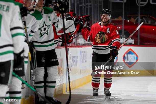 Alex DeBrincat of the Chicago Blackhawks celebrates with teammates after scoring a goal in the second period against the Dallas Stars at the United...
