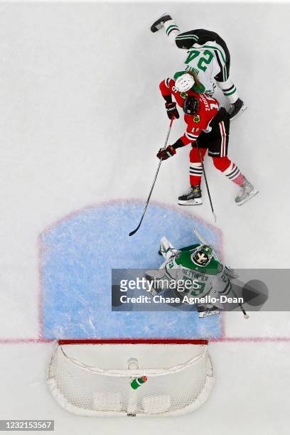 Nikita Zadorov of the Chicago Blackhawks attempts a shot while being defended by Roope Hintz and Jake Oettinger of the Dallas Stars in the third...