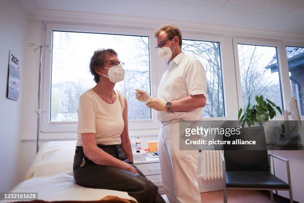 April 2021, Hamburg: Björn Parey, general practitioner, vaccinates his patient Christa Janssen with the Corona vaccine from Biontech/Pfizer in his...
