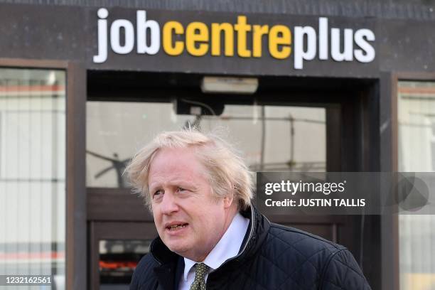 Britain's Prime Minister Boris Johnson walks past a Job Centre in Truro, Cornwall, southwest England on April 7, 2021. - British Prime Minister Boris...