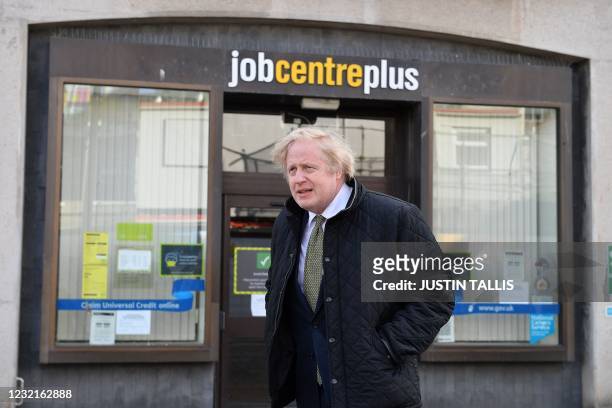 Britain's Prime Minister Boris Johnson walks past a Job Centre in Truro, Cornwall, southwest England on April 7, 2021. - British Prime Minister Boris...