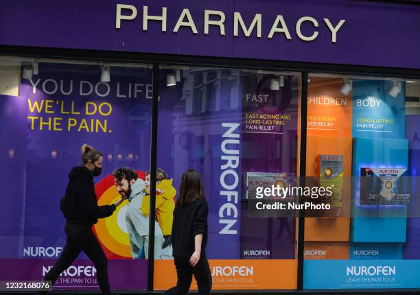 People walk past a Pharmacy window with the Nurofen ad, in Dublin city center, during Level 5 Covid-19 lockdown. On Wednesday, 7 April 2021, in...