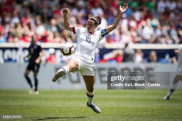 Captain Carli Lloyd of United States jumps to kick the ball and keep control with the Powerade logo behind her during the International Friendly...