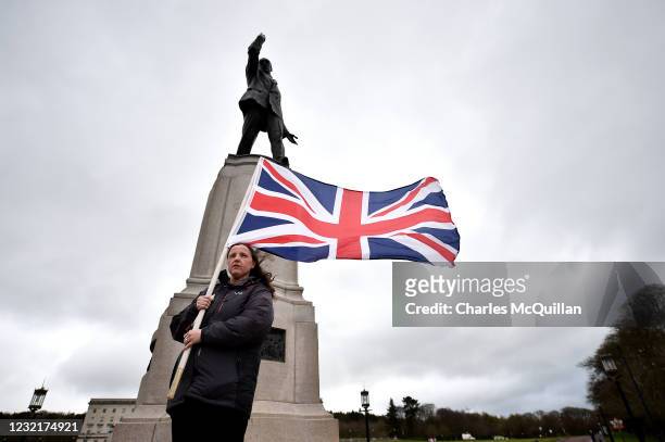 Unionist stands under Edward Carson’s statue holding a Union Jack Flag at Stormont on April 8, 2021 in Belfast, Northern Ireland.