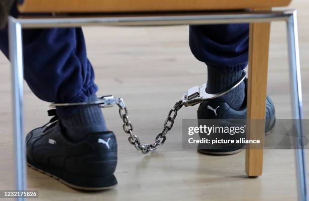 April 2021, Mecklenburg-Western Pomerania, Neubrandenburg: The defendant wears shackles at the beginning of the trial for serious child abuse in the...