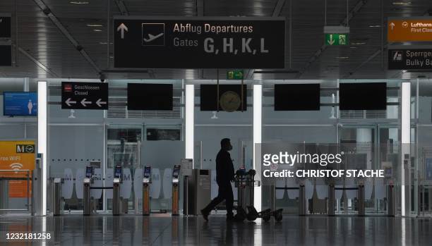 Passenger walks in a terminal of the Franz-Josef-Strauss airport in Munich, southern Germany, on April 8 amid the ongoing novel coronavirus Covid-19...