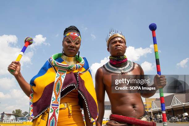 Activist Nqobile Maluku and Thando Mahlangu wearing traditional attire raise their fists during a protest outside the Boulders Shopping Centre, after...