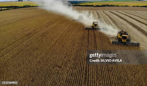 Aerial view of combine harvesters being used to harvest soybeans in a field at Salto do Jacui, in Rio Grande do Sul, Brazil, on April 5, 2021. - Rio...