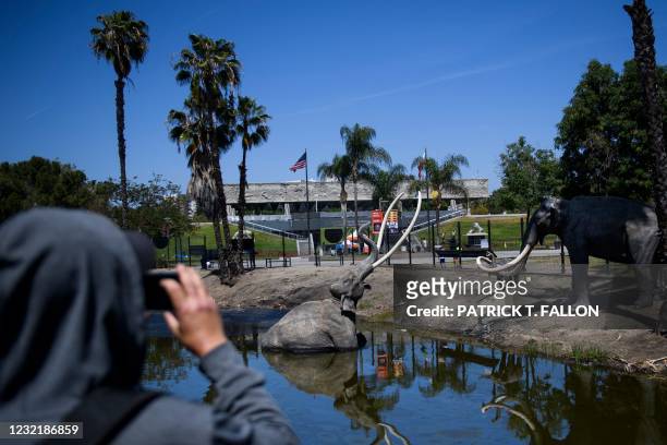 Visitor takes pictures of the La Brea Tar Pits outside the museum, which was closed over a year ago due to the Covid-19 pandemic, on April 8, 2021 in...