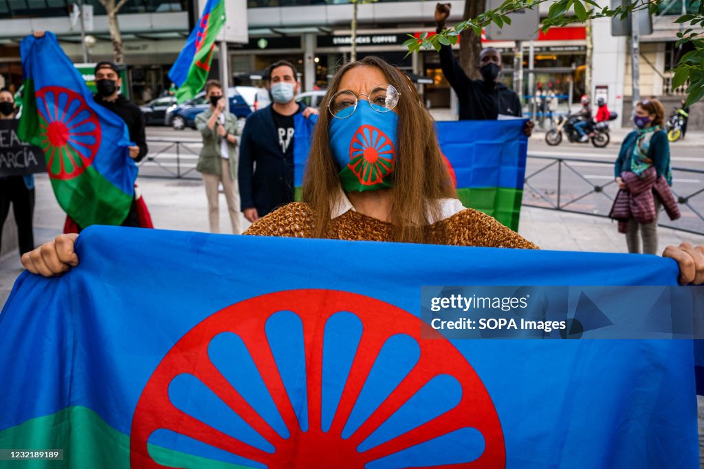 A group of gypsy protesters hold flags during the...