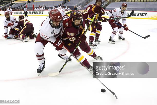 Anthony Del Gaizo of the Massachusetts Minutemen battles for puck against Connor Kelley of the Minnesota Duluth Bulldogs during the Division I Men's...