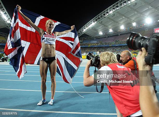 Hannah England of Great Britain celebrates with her country's flag in front of photographers after claiming silver in the women's 1500 metres final...