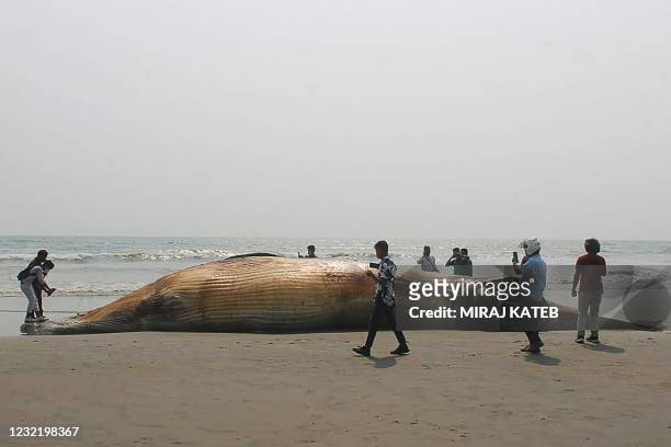 Onlookers stand around a dead whale washed ashore at a beach in Cox's Bazar on April 9, 2021. - Bangladesh's southeastern resort district of Cox's...