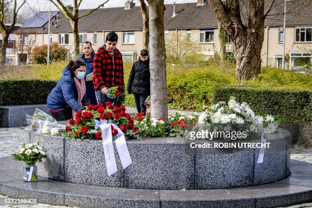 People lay flowers at a memorial for those killed at the Ridderhof shopping center in 2011, some 33 kilometers southwest of Amsterdam, on April 9,...