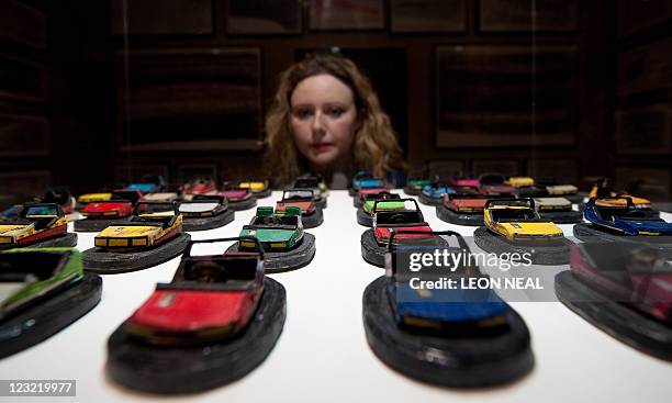 Woman looks at model bumpercars by German artist Uwe Breckner during the launch of the "Museum of Everything" art project installation at Selfridges...