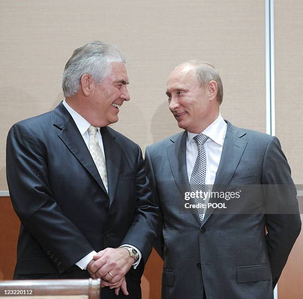 Russia's Prime Minister Vladimir Putin speaks with ExxonMobil President and Chief Executive Officer Rex Tillerson during the signing of a...