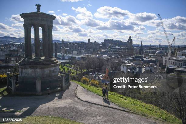 People jog at Calton Hill Cemetery overlooking the Old Town with Dugald Stewart Monument on Calton Hill as the country responds to the announcement...