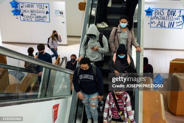 Students from the new Downtown Burlington High School use the building's escalators to get between floors and classes at a closed Macy's department...