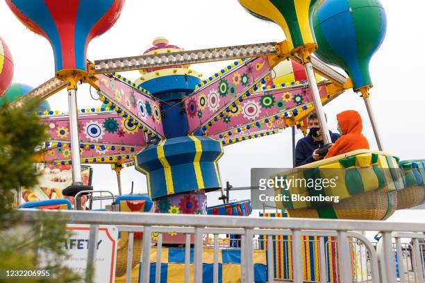 Visitors wear protective masks while on a ride at Deno's Wonder Wheel Amusement Park in the Coney Island neighborhood in the Brooklyn borough of New...
