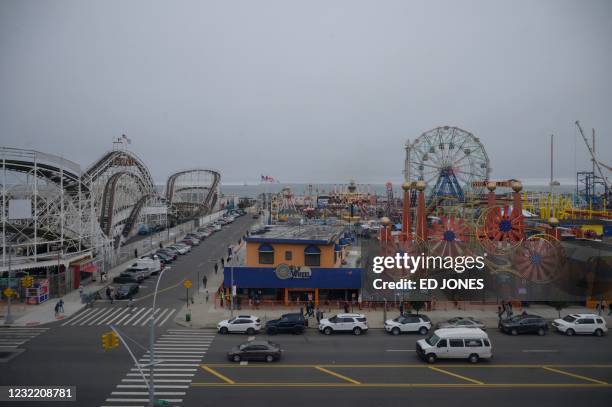 Visitors ride attractions on the opening day of the 2021 season at the Luna Park amusement park in Coney Island, New York on April 9, 2021. - After...