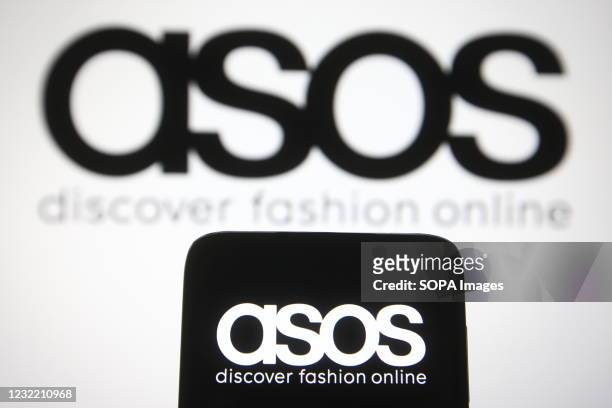 In this photo illustration the ASOS logo of a British online fashion and cosmetic retailer is seen on a smartphone and a pc screen.