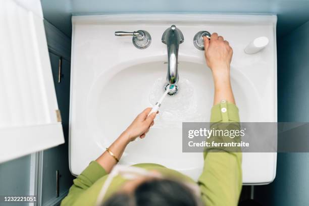 woman brushing teeth - women with health faucet stock pictures, royalty-free photos & images