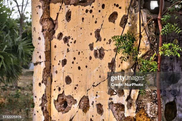 Building riddled with bullet holes during the civil war in Mugamalai, Sri Lanka. This is just one of the many reminders of the deep scars caused...