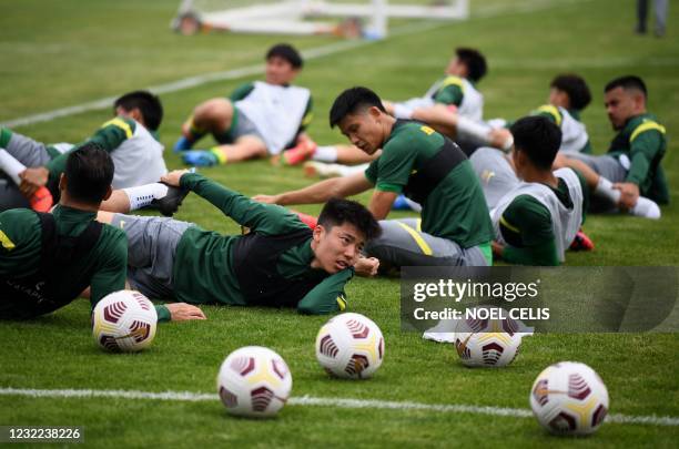 Beijing Guoan Football Club players stretch during a training session at the Fengtai stadium in Beijing on April 11, 2021.