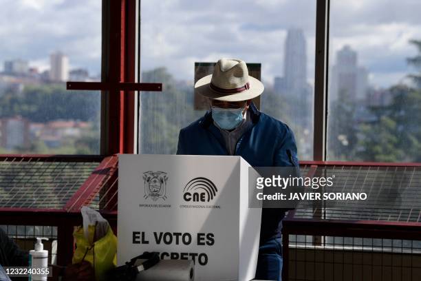 An Ecuadoran resident chooses ballots before casting his vote for the second round of Presidential elections at a polling station at the Casa de...