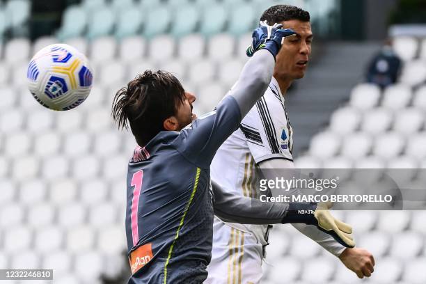 Genoa's Italian goalkeeper Mattia Perin and Juventus' Portuguese forward Cristiano Ronaldo go for the ball during the Italian Serie A football match...