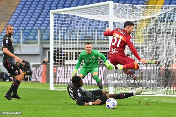 Bologna's French Malian defender Bakary Adama Soumaoro tackles Roma's Spanish midfielder Carles Perez as Bologna's Polish goalkeeper Lukasz Skorupski...