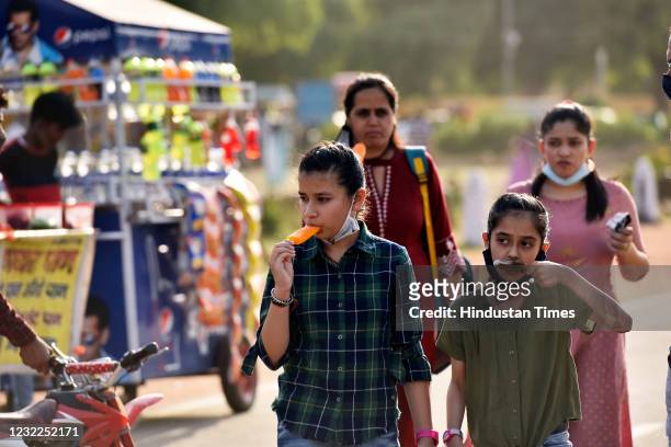 Visitors enjoy Ice cream on a Hot Day near India Gate, on April 11, 2021 in New Delhi, India.