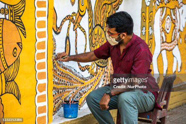 Teacher of Faculty of Fine Arts of Dhaka University painting a wall for preparation to celebrate upcoming Bengali New Year 1428 during the last day...