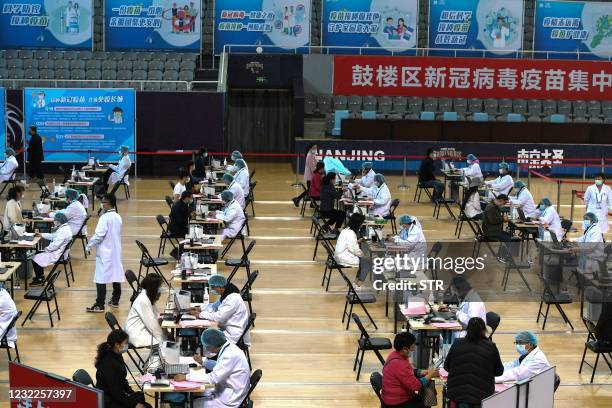 This photo taken on April 10, 2021 shows people registering information before receiving a vaccine against the Covid-19 coronavirus in Nanjing, in...