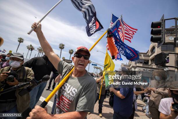 An Evangelical Christian Donald Trump supporter carries flags at the site of a "White Lives Matter" rally on April 11, 2021 in Huntington Beach,...