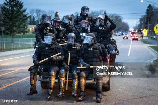 Minneapolis police officers in riot gear leave as protesters gather after an officer shot and killed a black man in Brooklyn Center, Minneapolis,...