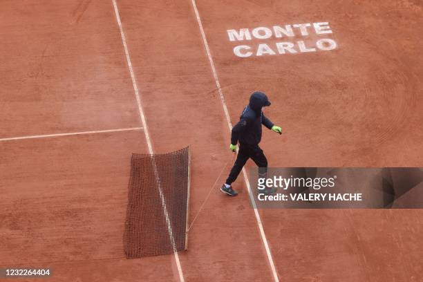 Member of the groundstaff sweeps the court following a break due to rain during the Italy's Lorenzo Musetti vs Russia's Aslan Karatsev first round...