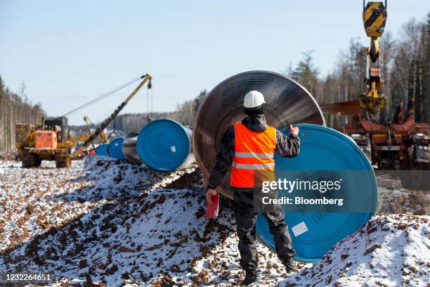 Worker removes a blue Gazprom branded end cap from a section of pipe during pipeline laying operations for the Gazprom PJSC Power of Siberia gas...
