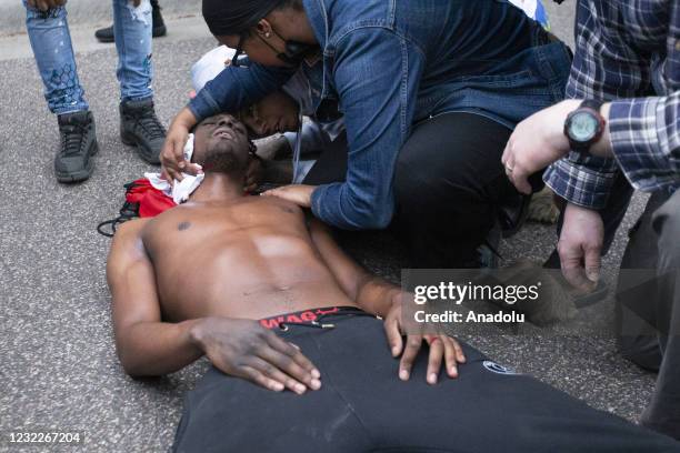 After being struck by a rubber bullet in the neck, protesters tend to a man laying on the ground after Brooklyn Center police killed Duante Wright...