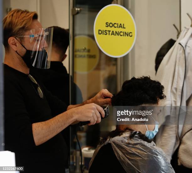 Man has his hair cut at the barbershop after the country enters the second stage of the government's roadmap out of the countryâs third nationwide...