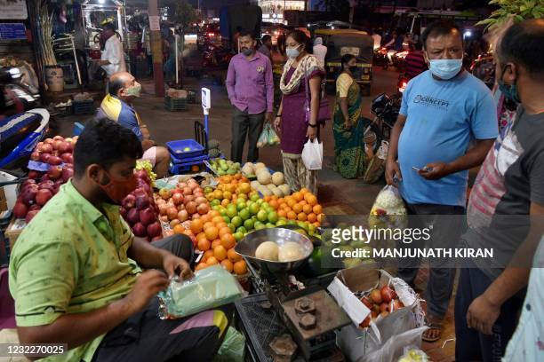 People shop for fruits on the eve of Ugadi festival in Bangalore on April 12, 2021.