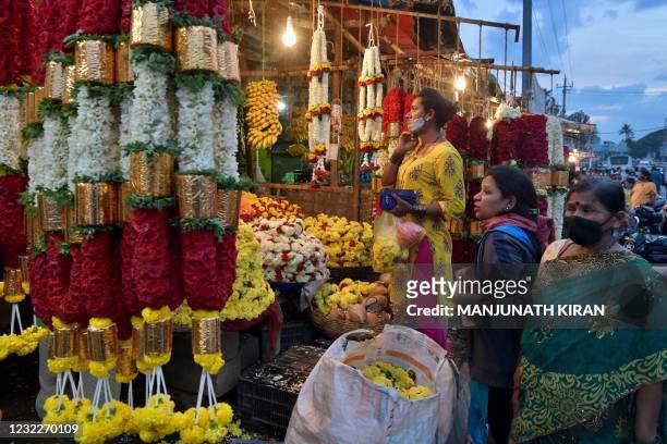 People shop for flower garlands on the eve of Ugadi festival in Bangalore on April 12, 2021.