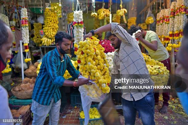 People shop for flower garlands on the eve of Ugadi festival in Bangalore on April 12, 2021.