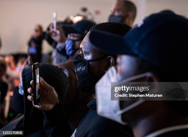 People watch as the body camera footage of the killing of 20-year-old Daunte Wright is played during a press conference at the Brooklyn Center police...